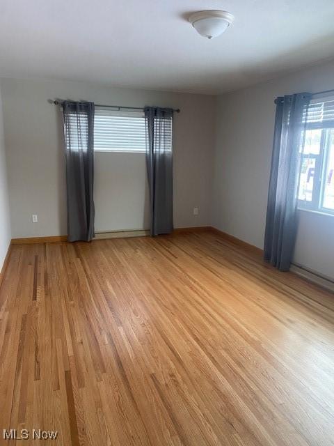 spare room with a healthy amount of sunlight and light hardwood / wood-style flooring