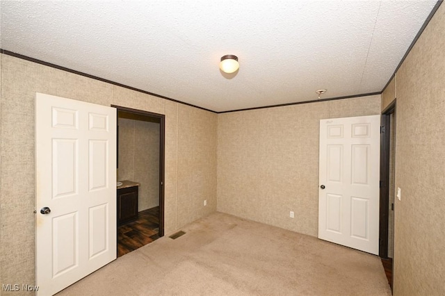 unfurnished bedroom featuring a textured ceiling and crown molding