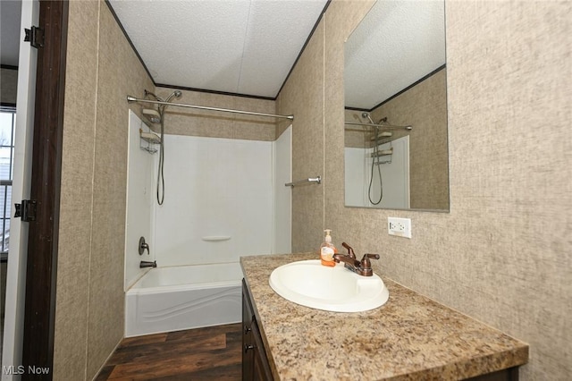 bathroom with bathing tub / shower combination, a textured ceiling, vanity, and wood-type flooring