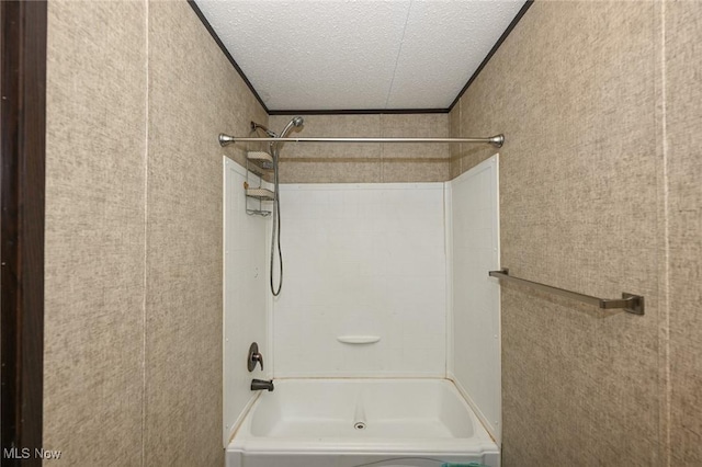 bathroom with a textured ceiling, ornamental molding, and shower / washtub combination