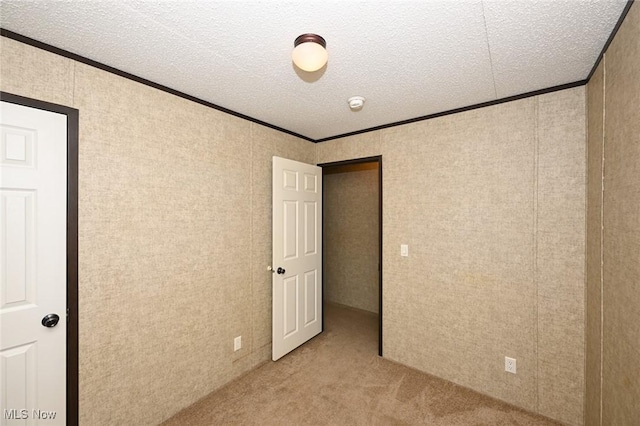 unfurnished bedroom with ornamental molding, light colored carpet, and a textured ceiling