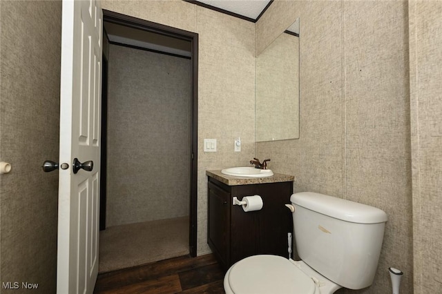 bathroom with ornamental molding, hardwood / wood-style floors, vanity, and toilet