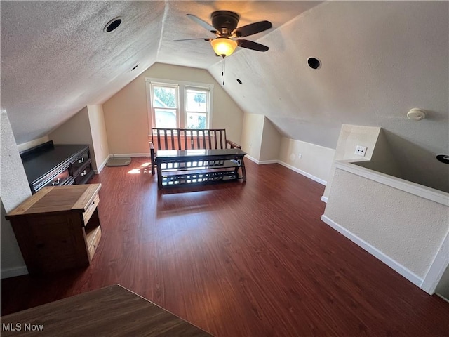 additional living space featuring ceiling fan, dark hardwood / wood-style flooring, a textured ceiling, and lofted ceiling