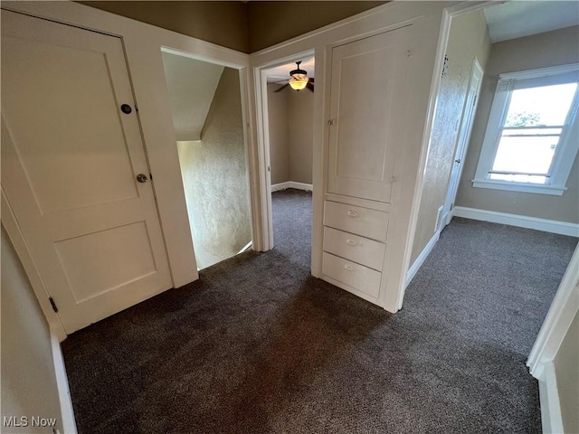 hallway with dark colored carpet