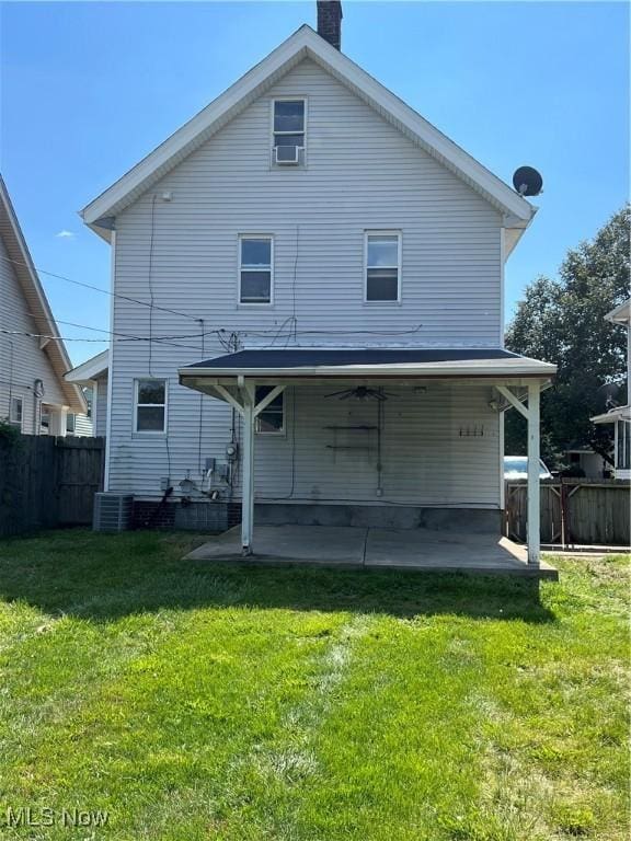 rear view of house featuring cooling unit, a yard, and a patio