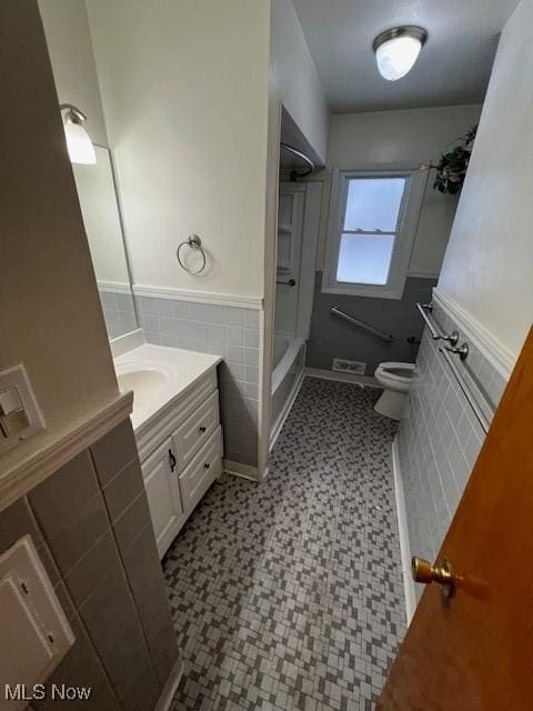 full bathroom with toilet, vanity, tile walls, and bathtub / shower combination