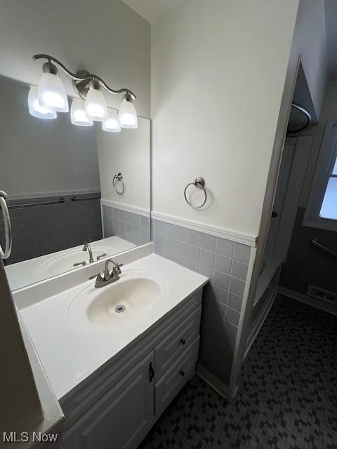 bathroom featuring tile walls and vanity