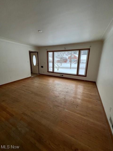 unfurnished living room with ornamental molding and dark hardwood / wood-style flooring