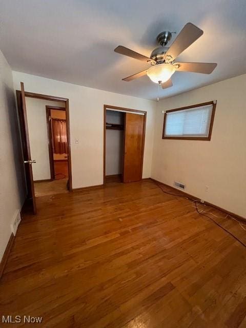 unfurnished bedroom featuring wood-type flooring, a closet, and ceiling fan