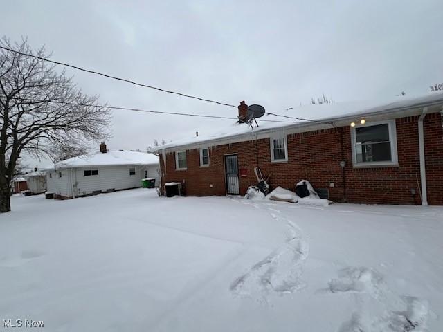 view of snow covered rear of property