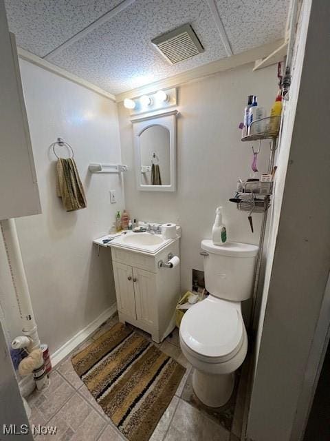 bathroom with a paneled ceiling, vanity, and toilet