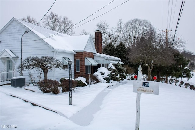 snow covered property featuring central air condition unit