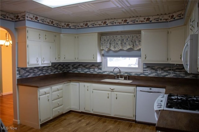 kitchen featuring white appliances, white cabinets, light wood-type flooring, and sink