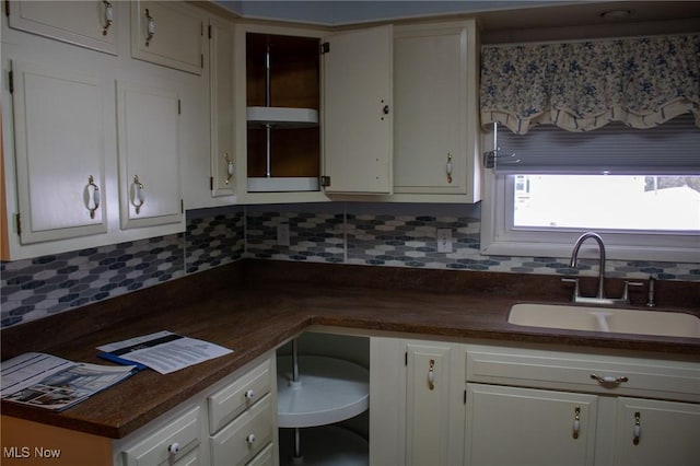 kitchen with sink, white cabinetry, and decorative backsplash