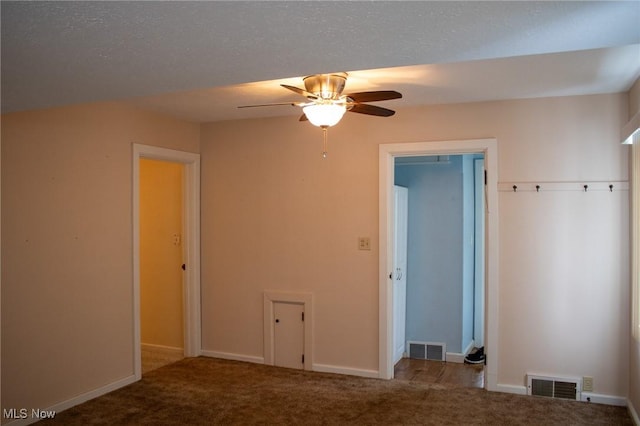 empty room with a textured ceiling, light carpet, and ceiling fan