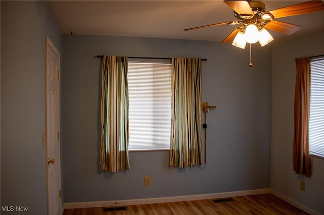 unfurnished room featuring ceiling fan, a healthy amount of sunlight, and hardwood / wood-style floors