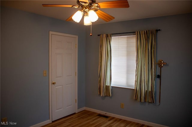 empty room with ceiling fan and wood-type flooring