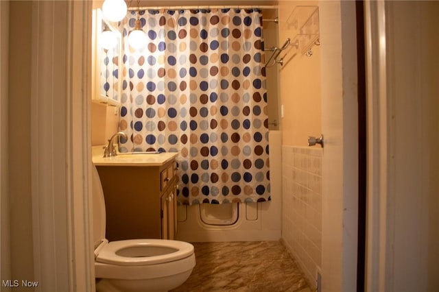 full bathroom with tile walls, shower / tub combo with curtain, vanity, and toilet