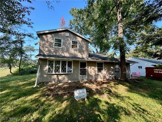 rear view of house featuring a lawn