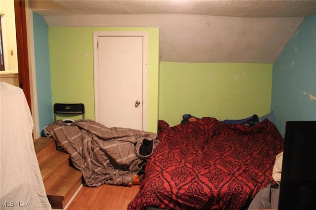 bedroom with a textured ceiling and hardwood / wood-style floors