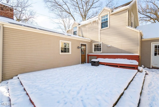 view of snow covered rear of property