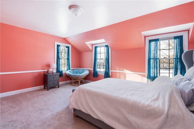 carpeted bedroom featuring vaulted ceiling and multiple windows