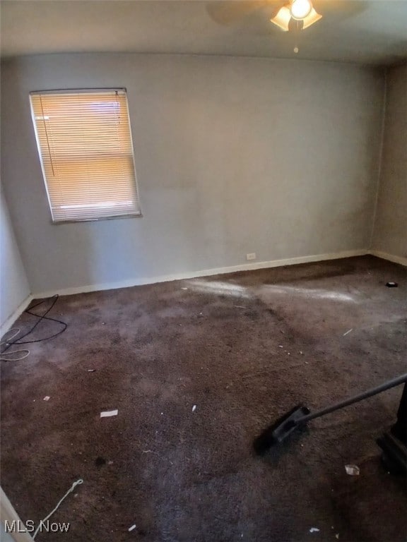 carpeted empty room featuring baseboards