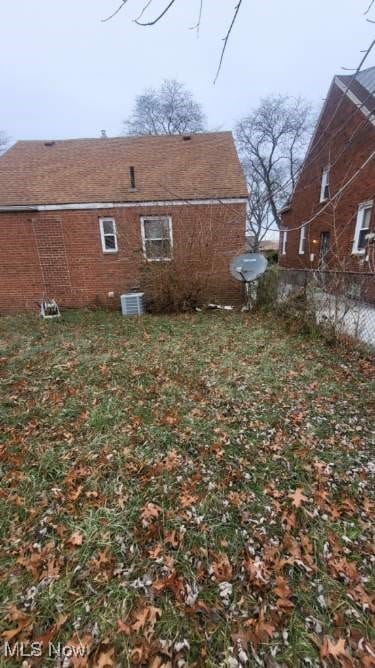 view of side of home with fence and central AC unit