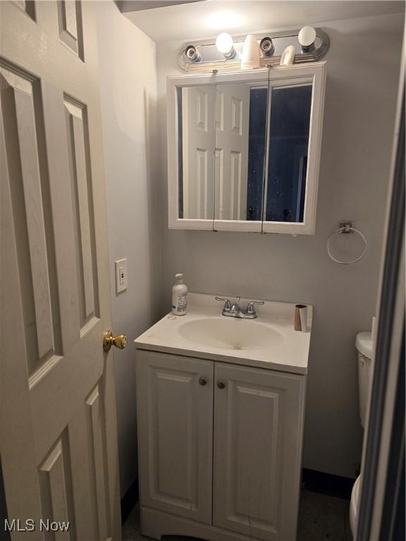 half bath featuring toilet and vanity