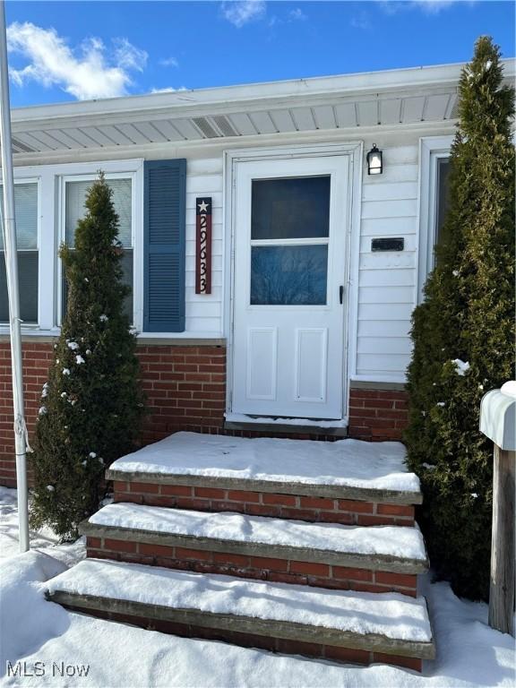 view of snow covered property entrance