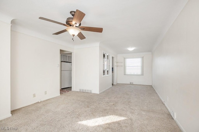 carpeted spare room with ceiling fan