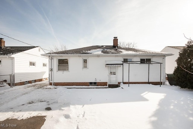 view of snow covered back of property