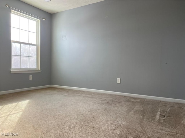 unfurnished room with carpet flooring and baseboards