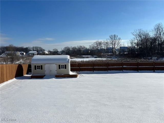 yard covered in snow with an outbuilding