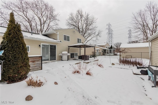 snow covered back of property with a gazebo