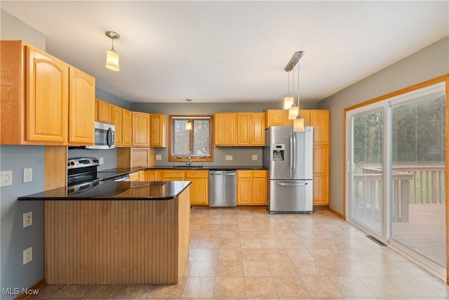 kitchen with pendant lighting, sink, kitchen peninsula, and appliances with stainless steel finishes