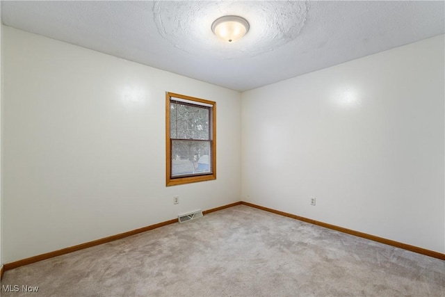 carpeted empty room with a textured ceiling