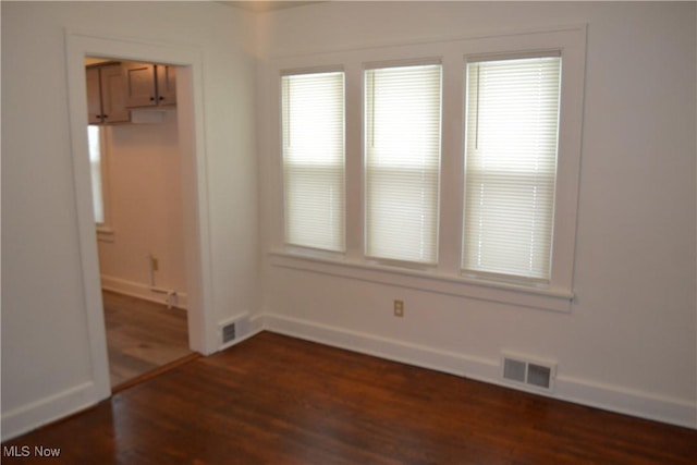 spare room featuring dark wood-type flooring