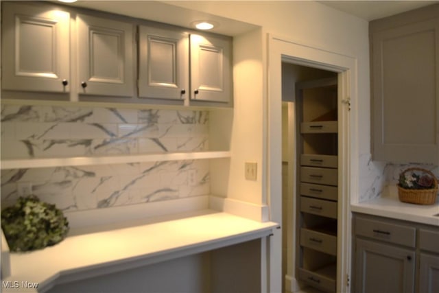 kitchen with decorative backsplash and gray cabinetry