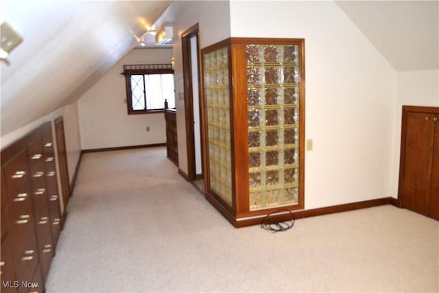 bonus room with vaulted ceiling and carpet flooring