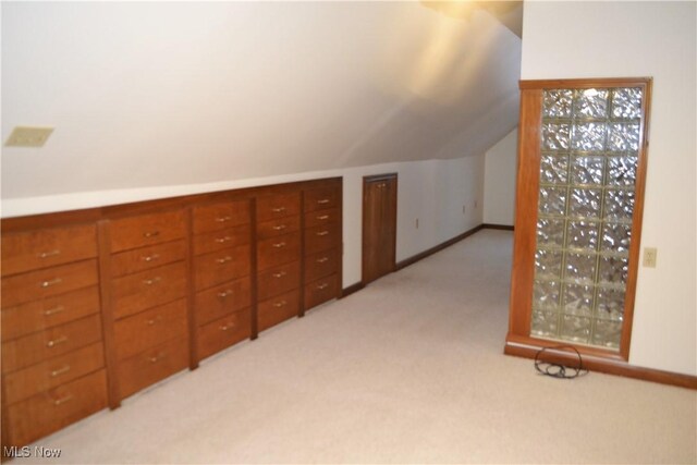 additional living space with lofted ceiling and light carpet