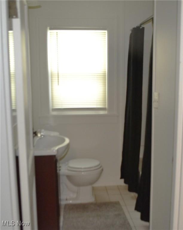 bathroom featuring walk in shower, vanity, and toilet