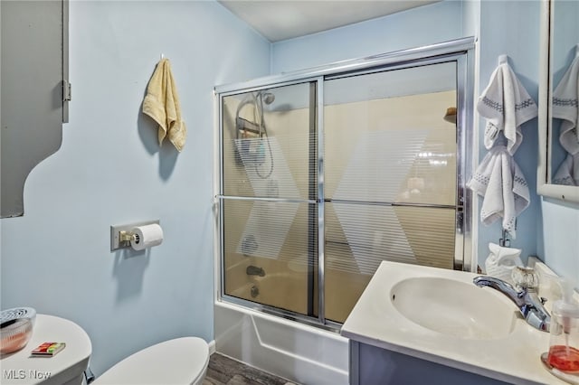 full bathroom featuring shower / bath combination with glass door, toilet, and vanity