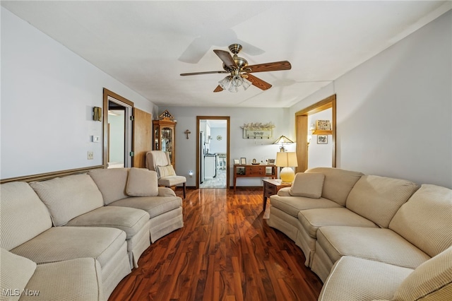 living room featuring dark wood-type flooring and ceiling fan