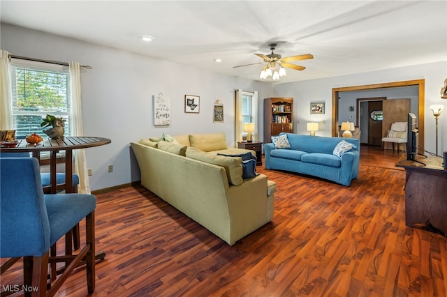 living room featuring ceiling fan and dark hardwood / wood-style floors