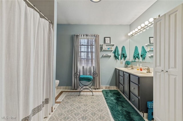 bathroom featuring tile patterned flooring, vanity, and toilet