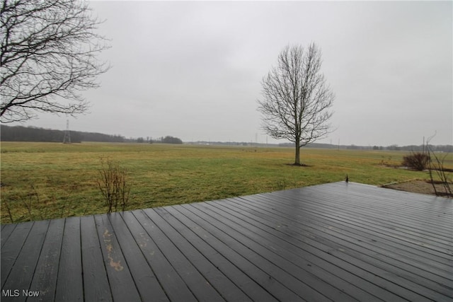 wooden terrace featuring a rural view and a lawn