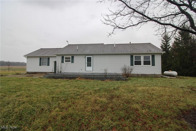 rear view of property with a yard and a wooden deck