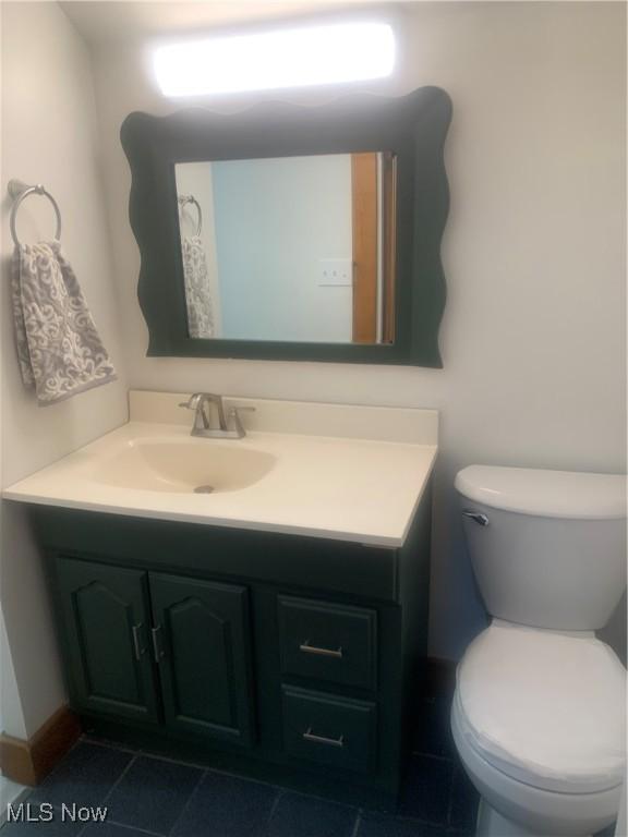 bathroom featuring toilet, tile patterned floors, and vanity