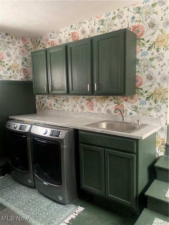 laundry room featuring independent washer and dryer, a sink, cabinet space, wainscoting, and wallpapered walls